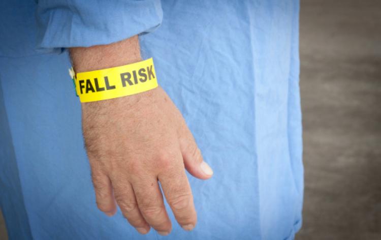 戴著黃色手鏈，上面寫著「有跌倒風險」的人。