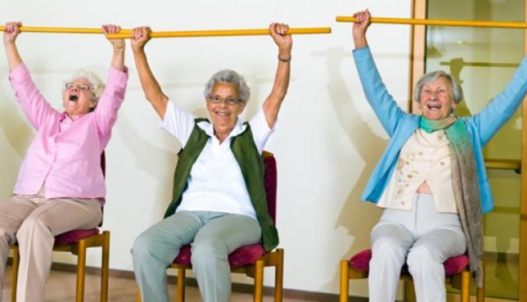 Tres mujeres haciendo ejercicios en una silla.