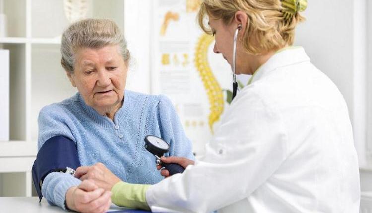 Un médico tomando la presión arterial de un paciente.
